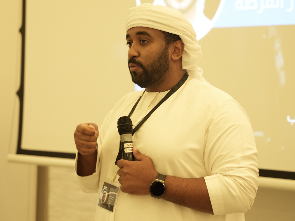 سيف الفلاسي متحدثاً بالميكروفون أمام الحضور